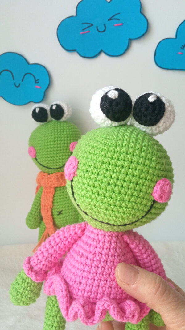 Kika es un amigurumi rana muy soñadora que siempre tiene la cabeza en las nubes, imaginando nuevos mundos llenos de magia y maravillas.